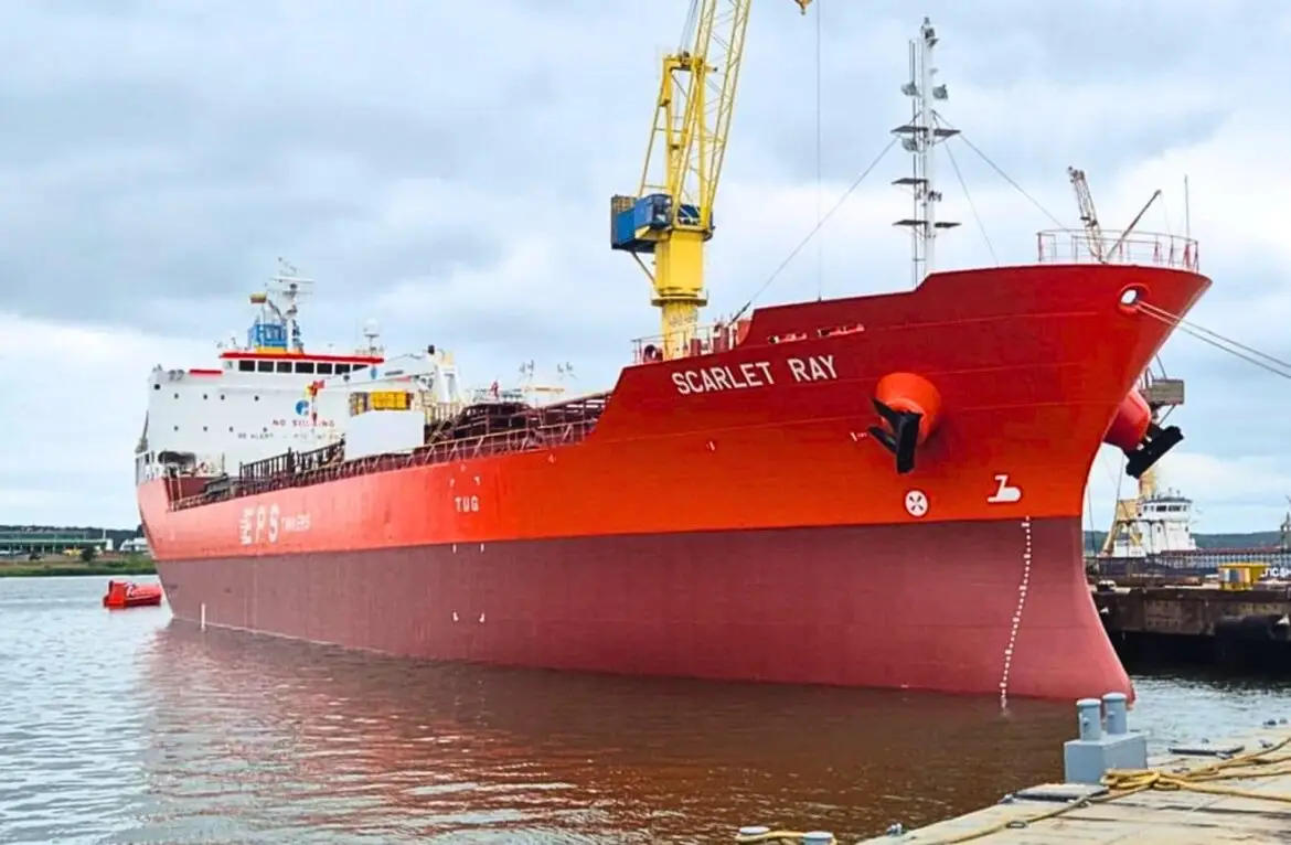 Oil tanker hit by missile, smoke rising from stern.
