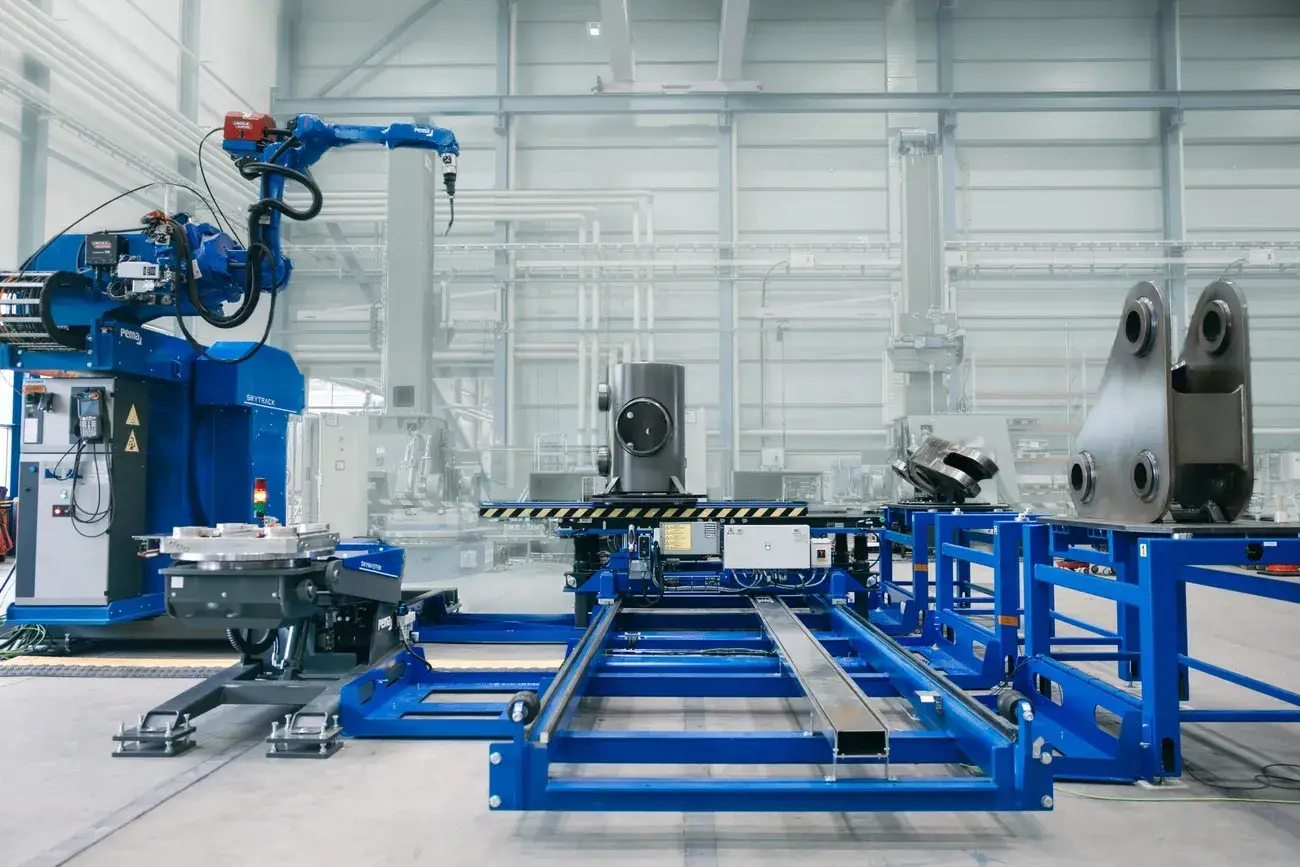 Advanced Pemamek automated welding machinery and robotic arm in a spacious industrial facility